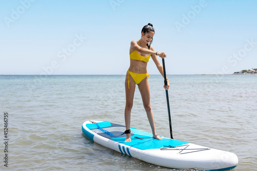 Girl paddling on top of a paddle surf board in the sea © FranciscoJavier
