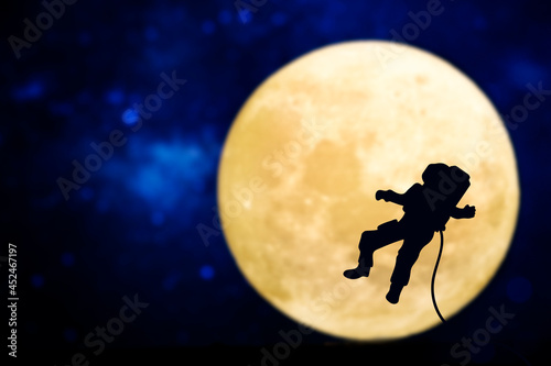 Spaceman silhouette over a full moon