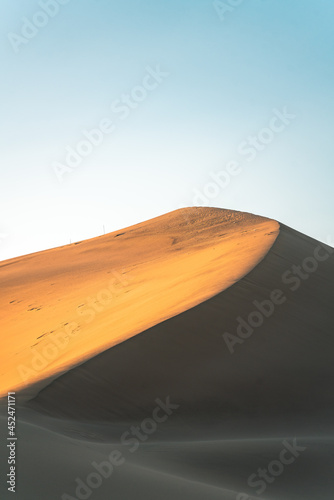 Fototapeta Naklejka Na Ścianę i Meble -  The sunset view of the dunes in deserts in Dunhuang, China.