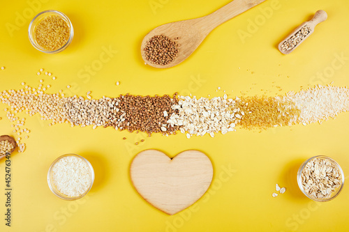 Flat lay of set of heap various grains and cereals on yellow background
