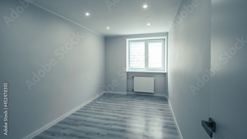 Contemporary interior of empty room. Apartment after renovation. White walls. Light parquet floor. Black and white.