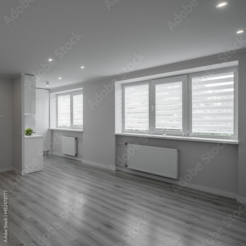 Studio apartment after renovation. Modern light interior in scandinavian style. White kitchen. Parquet floor.