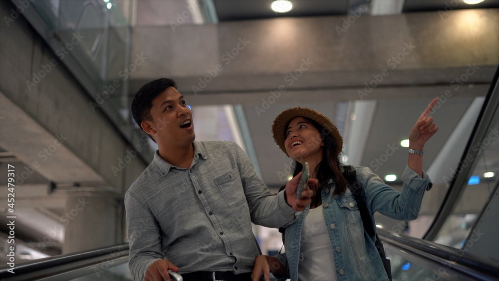 Couple Asian people in airport terminal waiting for flight boarding. Couple Asian people in airport terminal waiting for flight boarding.
