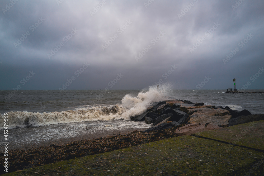 Stormy sea waves splashing to the jetty on Cape Cod beach