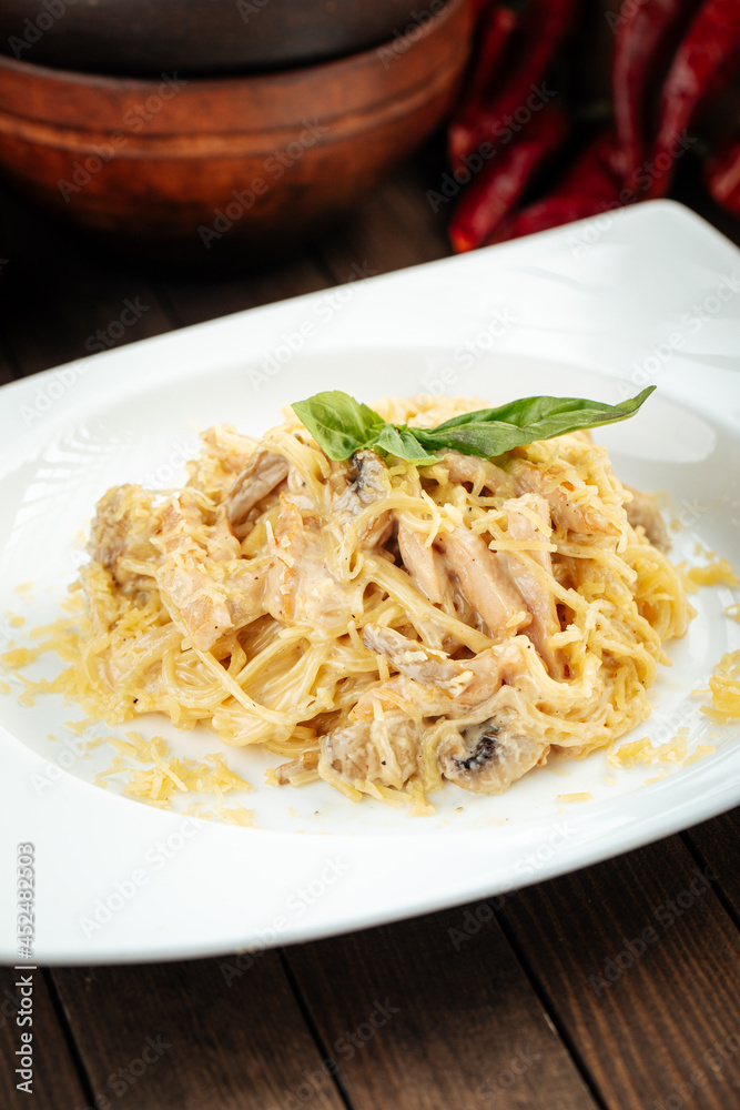 Carbonara paste with smoked chicken and mushrooms on wooden background Carbonara paste with smoked chicken and mushrooms on wooden background