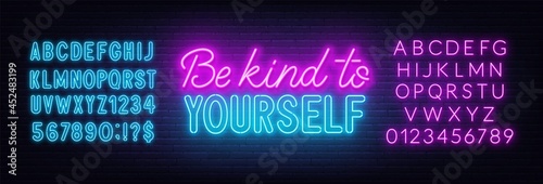Be kind to yourself neon sign on brick wall background.