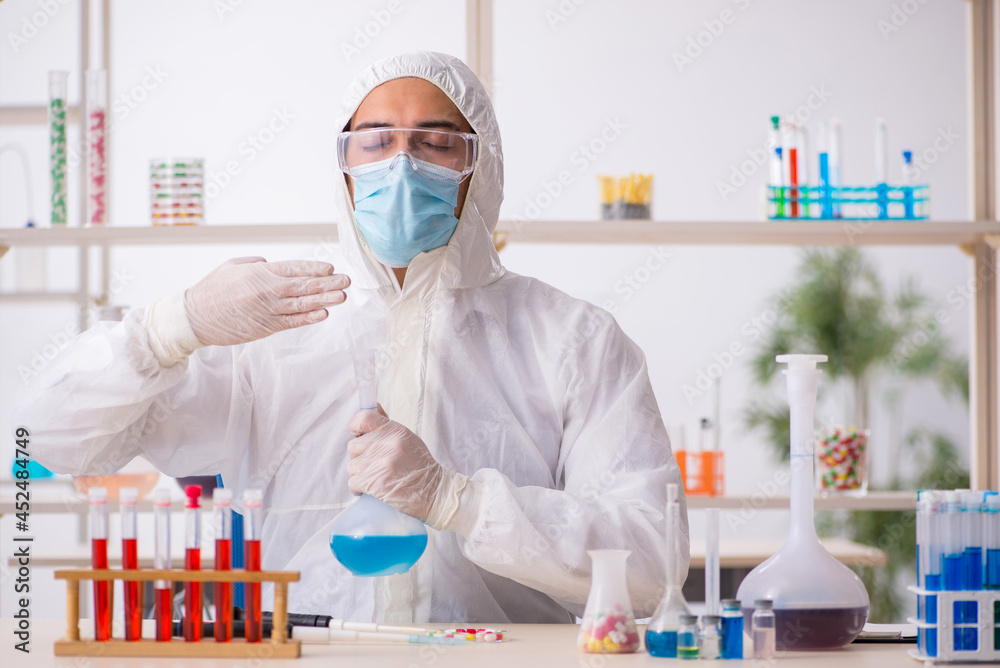 Young male chemist in drugs syntesis concept