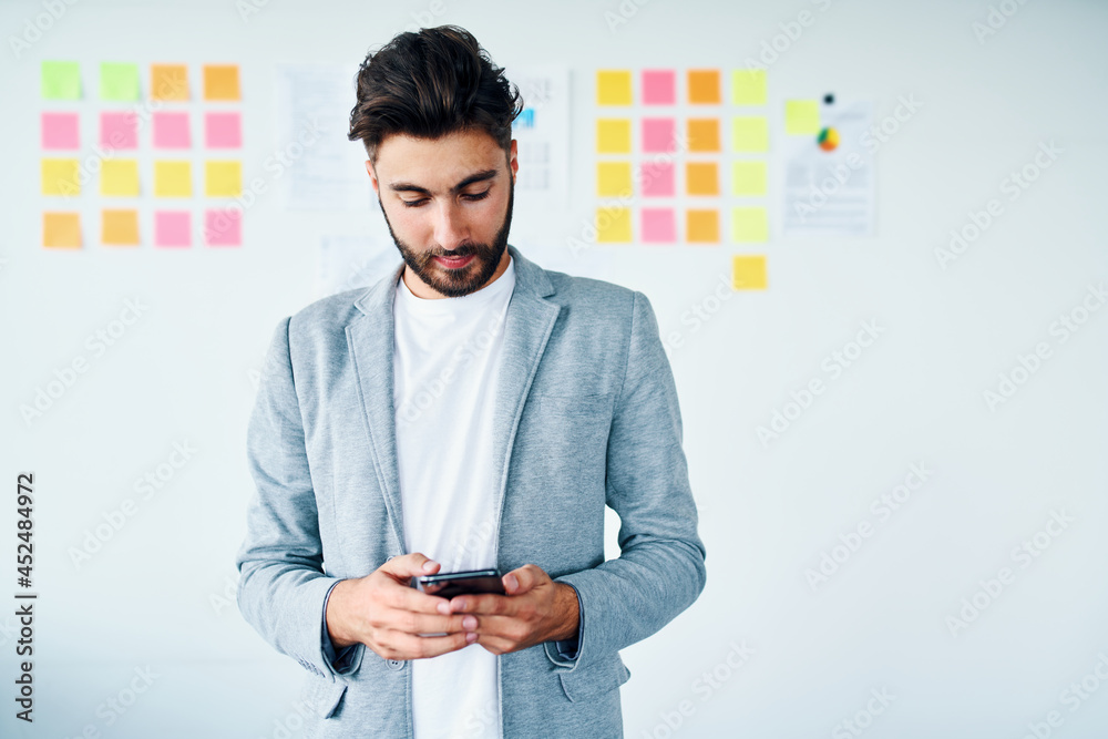 Young businessman using phone in startup office Young businessman using phone in startup office