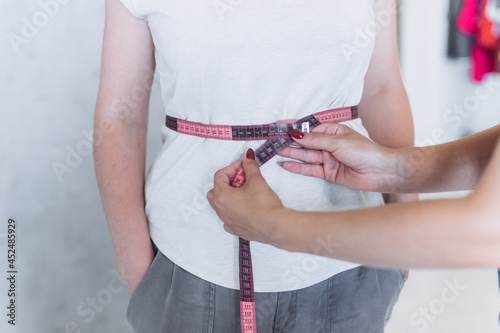 Young girl's waist is measured with a centimeter