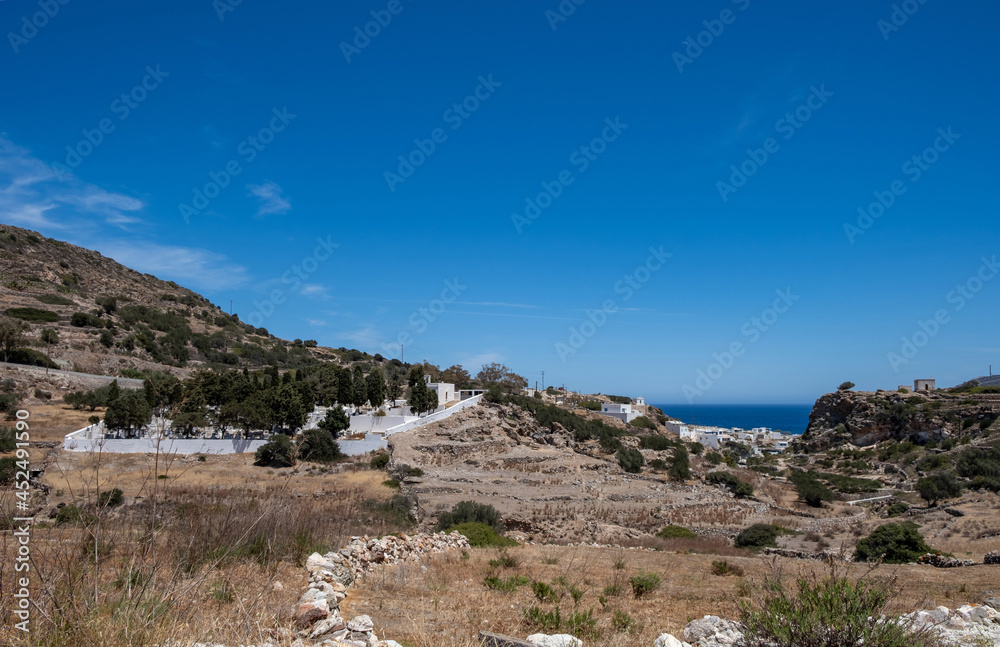Kimolos island, Chora village, Cyclades Greece. Cemetery at churchyard nature blue sky background.