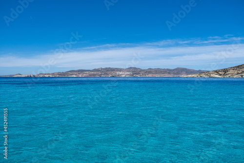 Polyaigos volcanic rocks formations transparent sea blue sky at Kimolos island, Cyclades Greece.