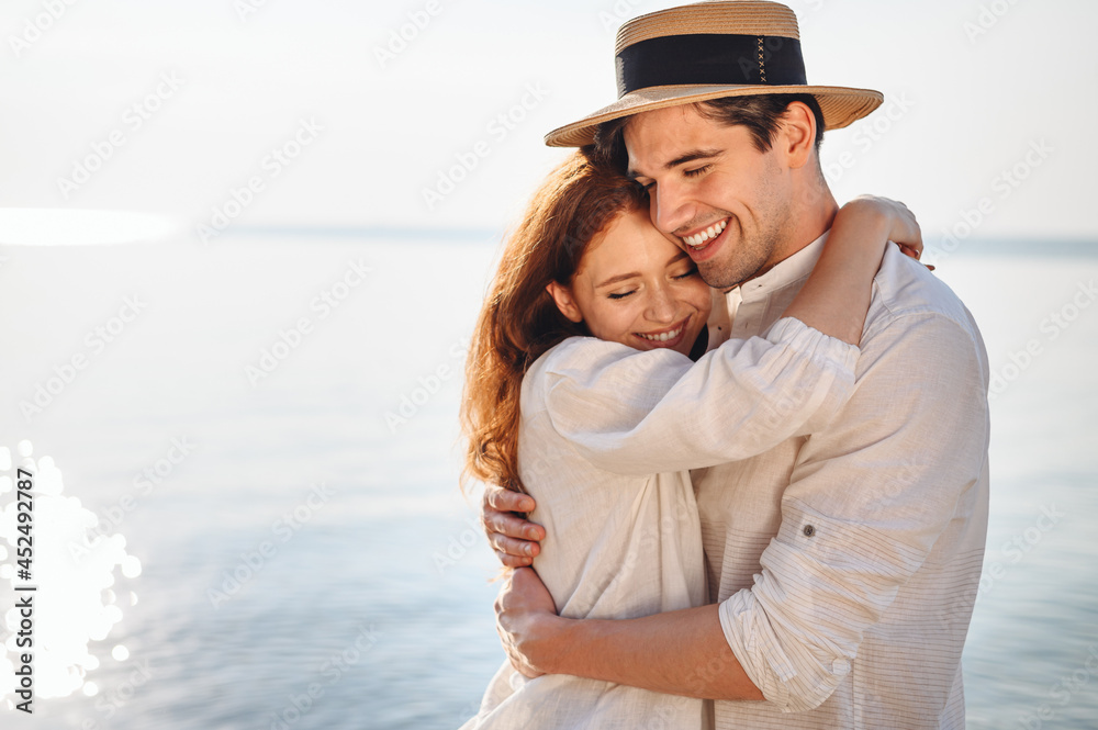 Side view happy young couple two family man woman wear casual clothes girlfriend hugging boyfriend rest date at sunrise over sea sand beach ocean outdoor exotic seaside in summer day sunset evening.