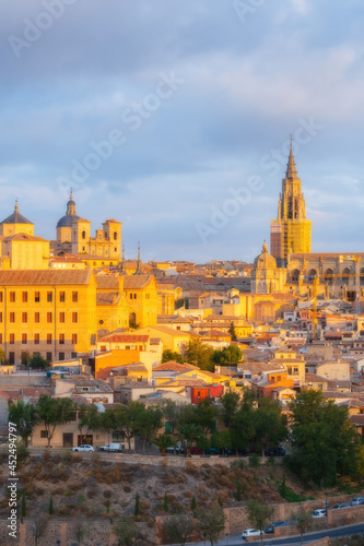 Cityscape in old city with colorful clouds at sunset; Cathedral and old town of Toledo, World Heritage Site, Spain. Close up vertical view