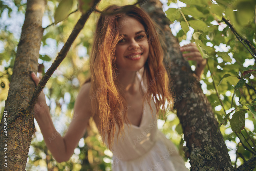 joyful red-haired woman in the forest near the tree nature summer joyful red-haired woman in the forest near the tree nature summer
