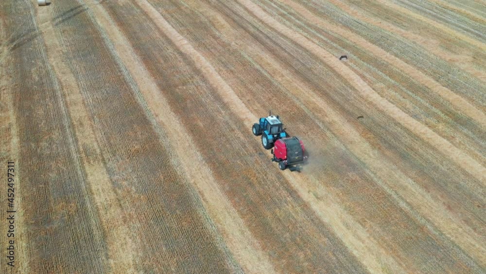 Blue tractor with red baler collects straw into bales.
Fly over a golden wheat field. There are wonderful landscapes around the fields. Blue tractor with red baler collects straw into bales.
Fly over a golden wheat field. There are wonderful landscapes around the fields.