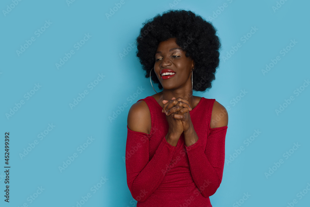 Young Black Woman In Elegant Top Is Holding Hands Together And Looking To The Side. Young Black Woman In Elegant Top Is Holding Hands Together And Looking To The Side.