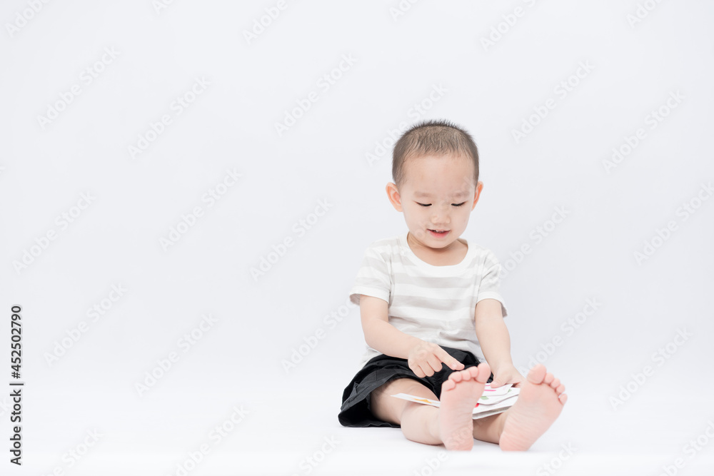 A little asian boy takes a portrait in a white background shed A little asian boy takes a portrait in a white background shed