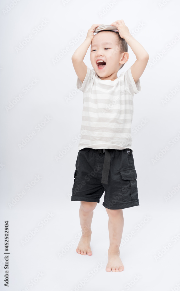 A little asian boy takes a portrait in a white background shed A little asian boy takes a portrait in a white background shed