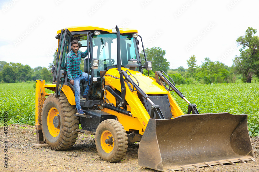 Indian man working with heavy equipment vehicle at construction site. Indian man working with heavy equipment vehicle at construction site.