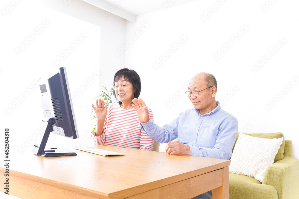 パソコンでテレビ電話をする高齢の夫婦 パソコンでテレビ電話をする高齢の夫婦