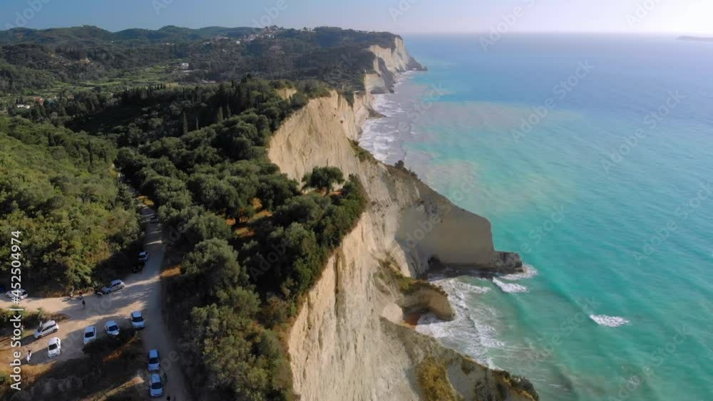 Flight over high cliffs of sea coast, aerial view. Northern part of island of Corfu, Greece.