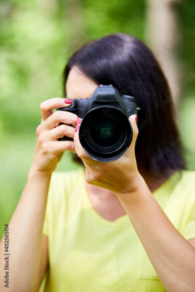 Portrait of a woman photographer covering her face with the camera Portrait of a woman photographer covering her face with the camera