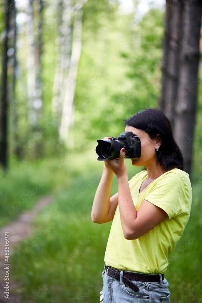 Portrait of a woman photographer covering her face with the camera
