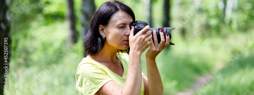 Φωτογραφία Banner of Portrait of a woman photographer covering her face with the camera