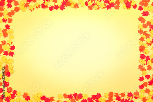 Falling maple leaves  paper confetti on a yellow background.