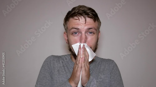 runny nose in a man holding tissue handkerchief blowing wiping his running nose.