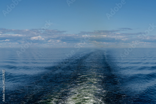 wake of a large ship in the calm open ocean under a blue sky