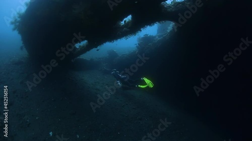 Freediver at USAT Liberty wreck in Bali. Woman freediver swims underwater near the shipwreck and explores the area photo