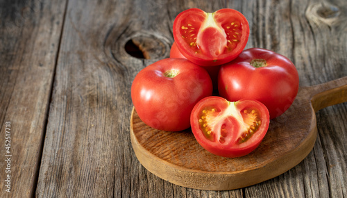 fresh ripe tomatoes on wood background. Copy Space