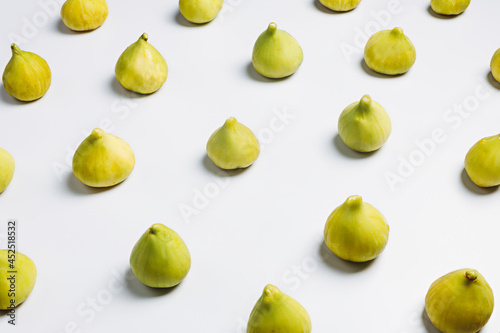 A collection of ripe and green whole figs on a bright white background. Creative autumn fruit concept. Vegetarian dessert diet idea.