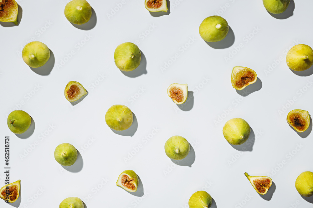 Pattern of ripe and juicy green figs on bright white background. Creative fall autumn fruit concept. Vegetarian diet idea. Flat lay. Pattern of ripe and juicy green figs on bright white background. Creative fall autumn fruit concept. Vegetarian diet idea. Flat lay.