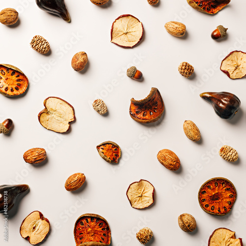 Texture made of autumn dry fruit on a bright white background. Creative fall season concept. Flat lay, top view.