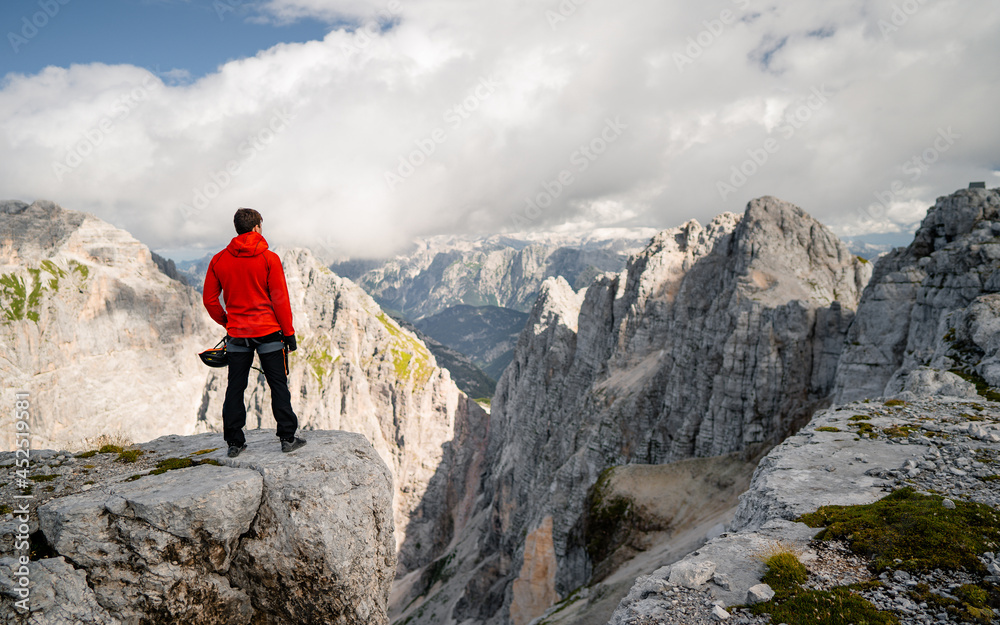 An alpinist climbing an mountain ridge. Climber ascent. Scenic landscape photo composite. Explore and Lifestyle 