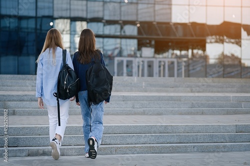 Back view of two students walking and talking in a university campus © D'Action Images