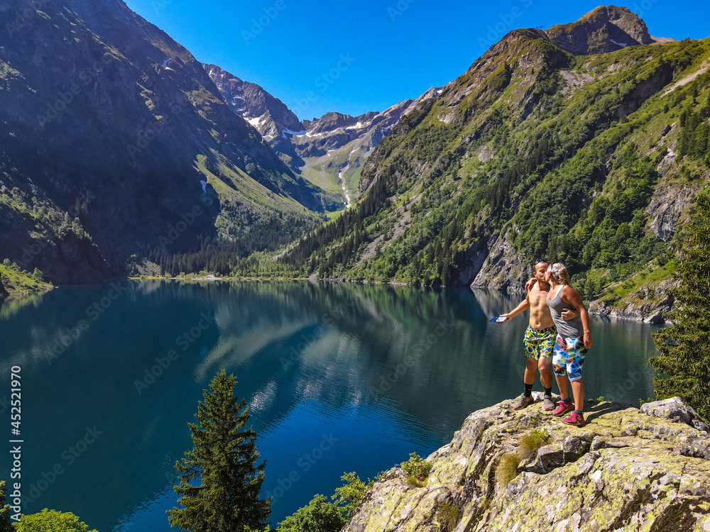 Couple stopping for picnic while hiking at the Lac Lauvitel in the French Alps