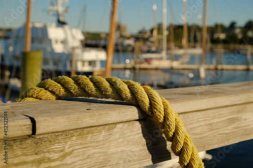 Yellow hemp rope tied on a dock railing