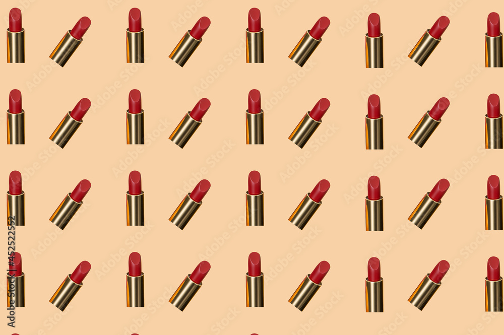 Creative pattern fashion photo of cosmetics beauty products red lipstick on a orange background Creative pattern fashion photo of cosmetics beauty products red lipstick on a orange background