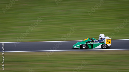 A panning shot of a racing kart as it circuits a track.