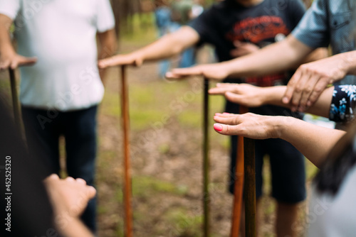  Close-up of the hands of people standing in a circle and holding sticks. Team building event for rallying and teamwork. High quality photo © Александра Вишнева