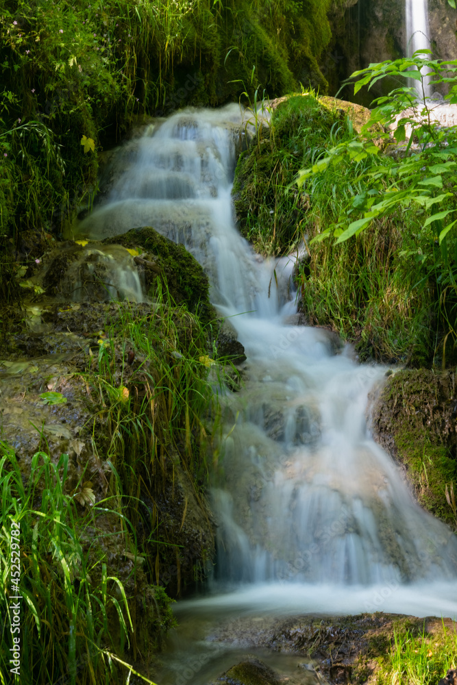 Obraz premium Wasserfall Bad Urach Brühl Bach Uracher Wasserfall Baden-Württemberg Deutschland Wald Idyll Bach Pflanzen nass feucht grün Schwäbische Alb Attraktion Kaskade Sommer Regen Wanderung Langzeit