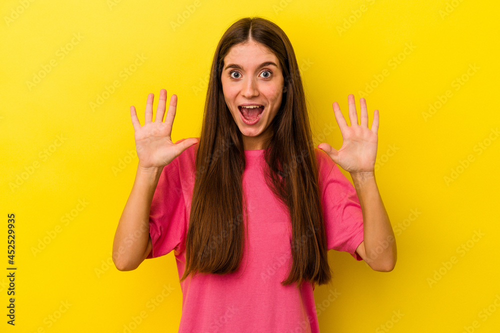 Young caucasian woman isolated on yellow background receiving a pleasant surprise, excited and raising hands. Young caucasian woman isolated on yellow background receiving a pleasant surprise, excited and raising hands.