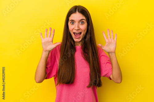 Young caucasian woman isolated on yellow background receiving a pleasant surprise, excited and raising hands.
