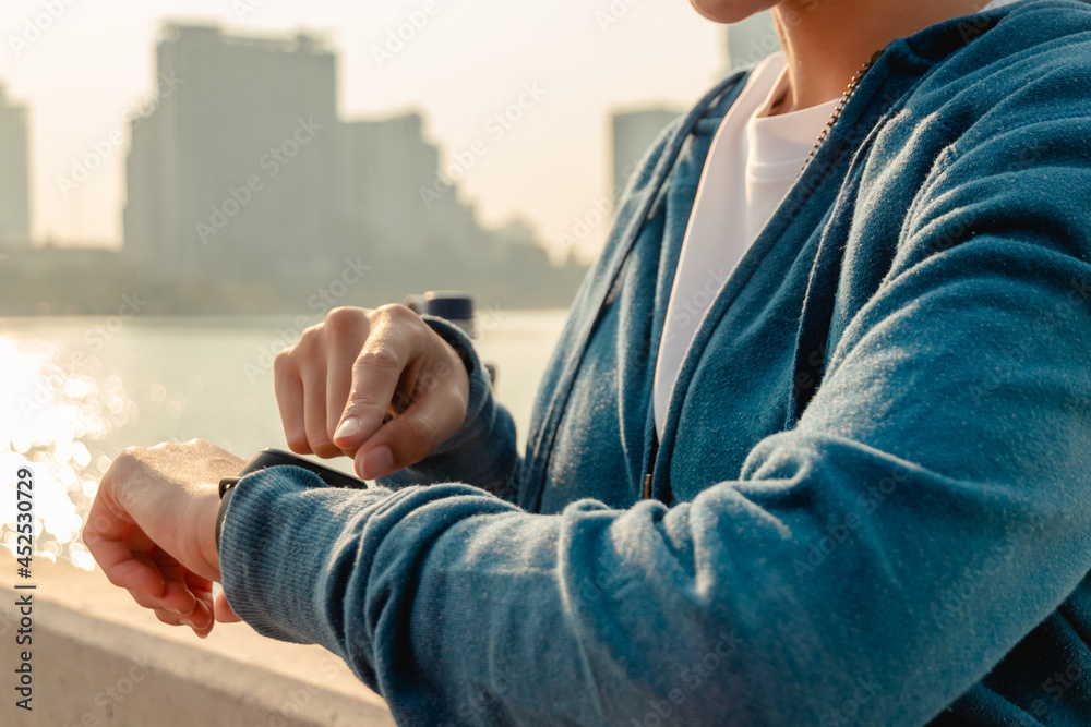 Close up hands using smart watch to monitor performance. Sport woman is setting up her smart watch before run. Close up hands using smart watch to monitor performance. Sport woman is setting up her smart watch before run.