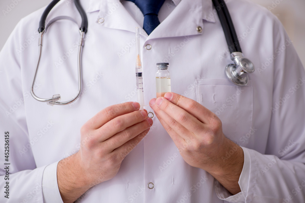 Young male doctor in vaccination concept