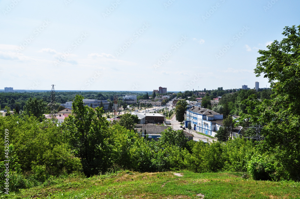 Panoramic view from the dais to the city of Bryansk. Green trees and city buildings.