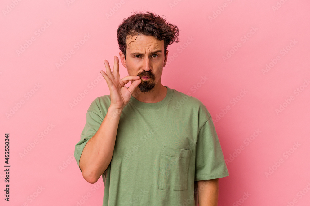 Young caucasian man isolated on pink background with fingers on lips keeping a secret. Young caucasian man isolated on pink background with fingers on lips keeping a secret.